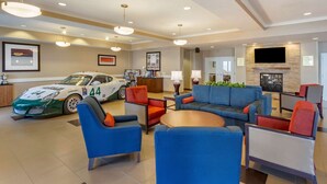 A modern lobby with a large screen, seating area, and a race car. - Comfort Inn & Suites Tooele - Salt Lake City (Tooele)