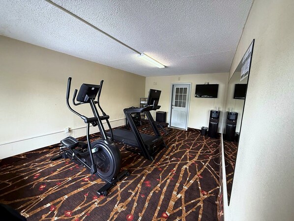Habitación de hotel con caminadora, elíptica y bicicleta estática.