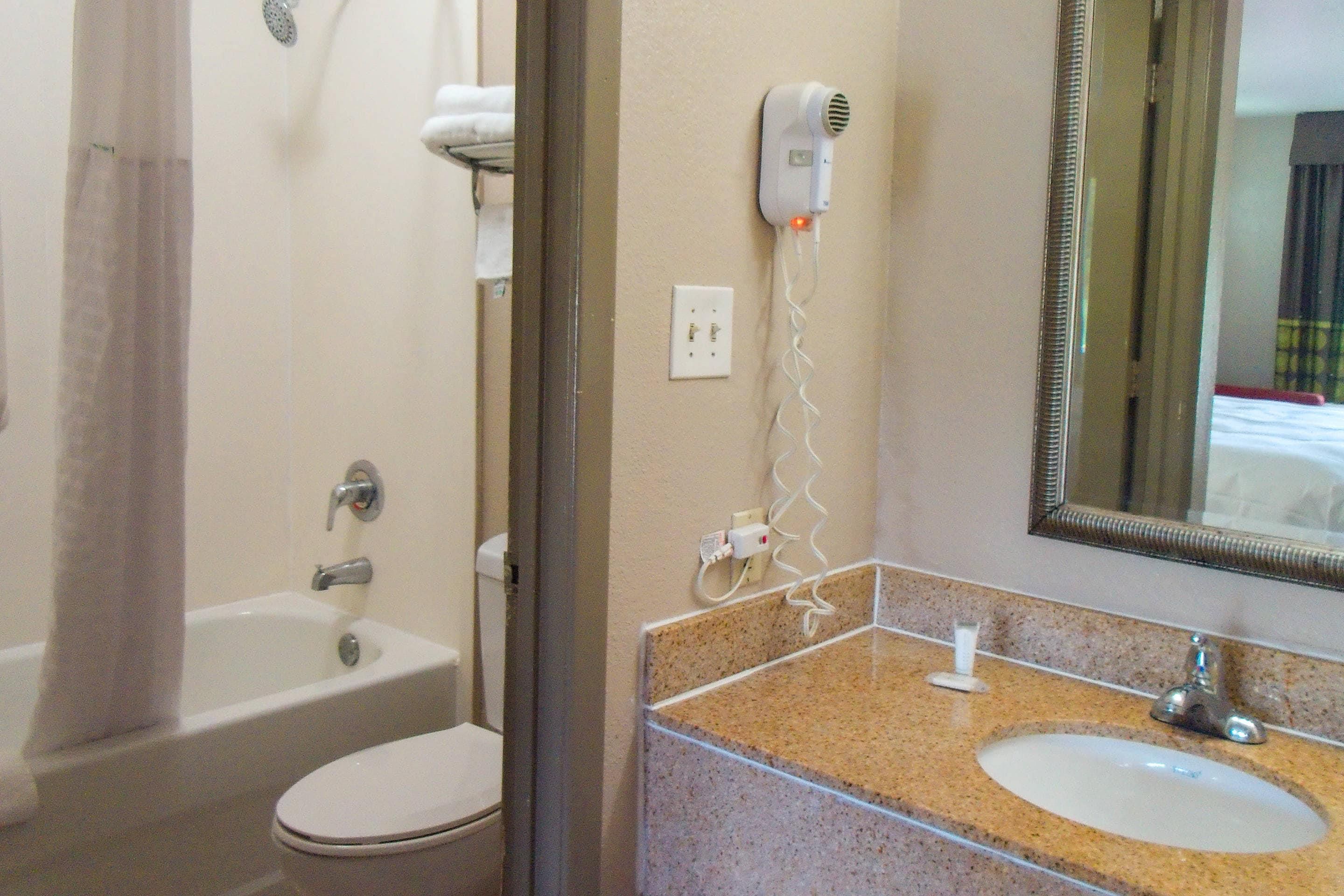 Une salle de bain avec une baignoire, des toilettes et un lavabo avec un miroir.