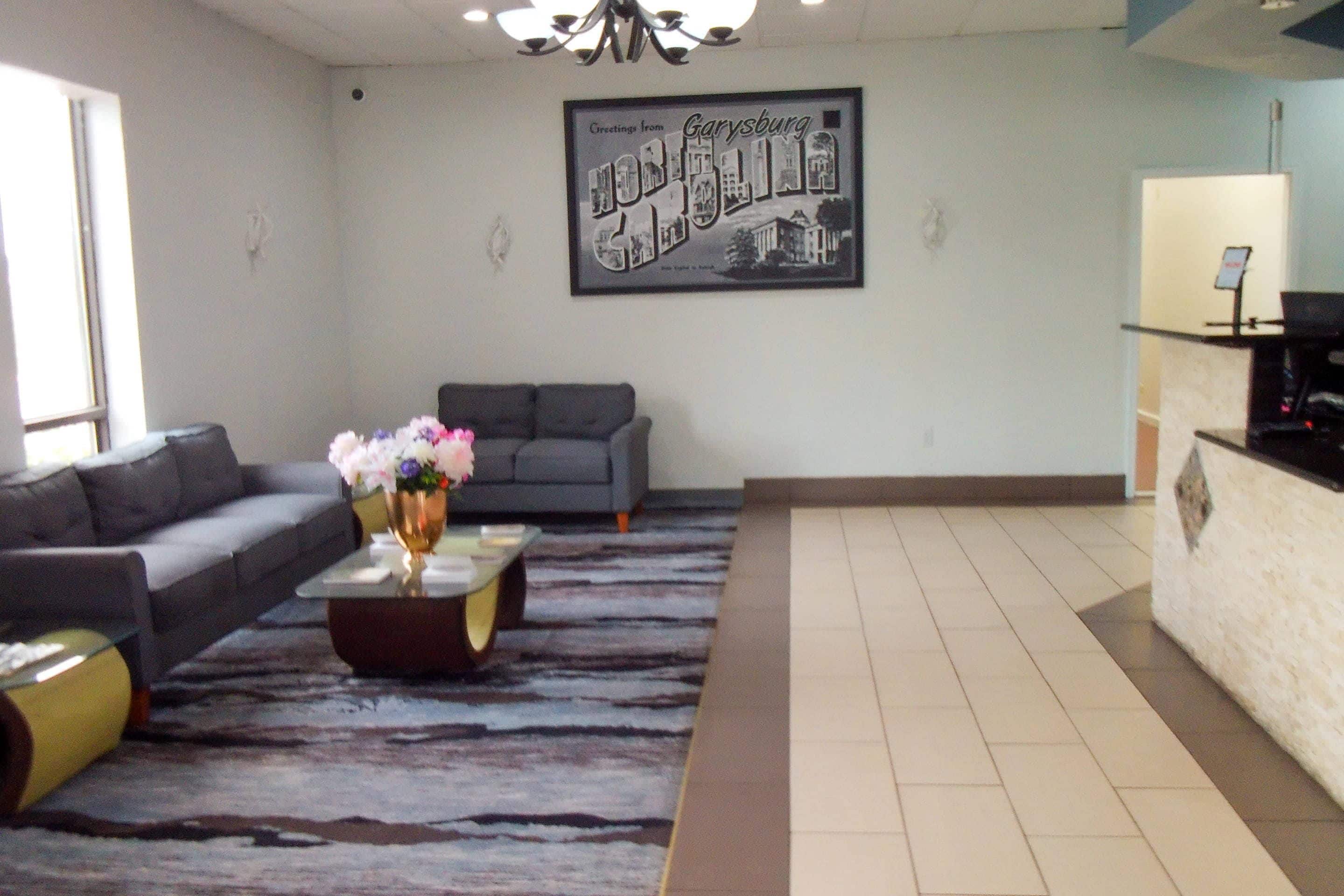 A modern living room with a sofa, a coffee table with flowers, and a framed cityscape picture on the wall.