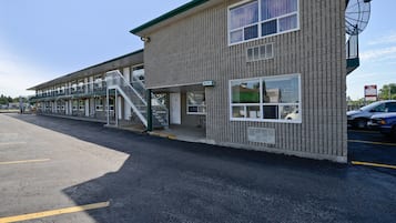 A two-story building with a brick facade, a satellite dish, and a sign indicating an office.