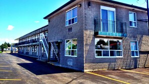 A two-story building with a brick facade, large windows, and a balcony. - Angus Inn (Essa)