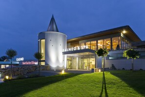 Experience the sleek, contemporary design of BALNEO & SPA, featuring a striking cylindrical tower and expansive glass windows.