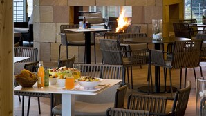 A restaurant with stone walls, wooden beams, and a fire feature. Tables and chairs are arranged for dining. - Resort Barrière Ribeauvillé (Ribeauvillé)