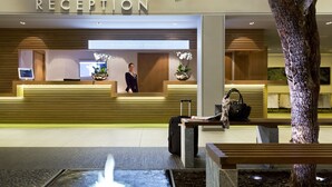 A reception area with a reception desk, a digital screen, and a water feature. - Resort Barrière Ribeauvillé (Ribeauvillé)
