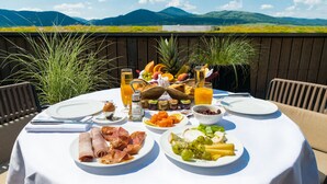 A table set for breakfast with various foods and drinks, overlooking a scenic landscape. - Resort Barrière Ribeauvillé (Ribeauvillé)