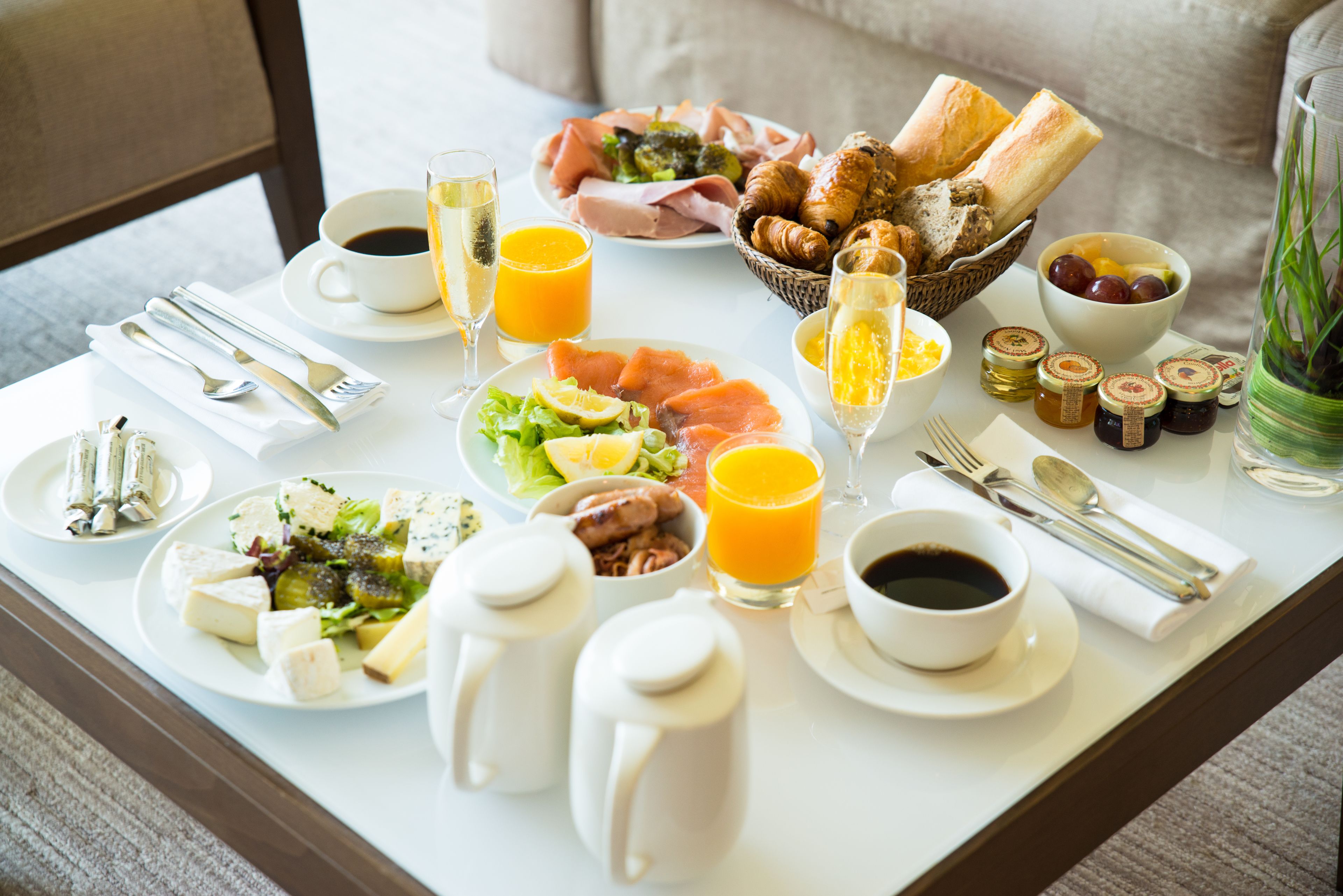 Una mesa de desayuno con diversos alimentos, bebidas y acompañamientos.