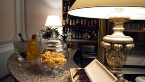 Zona de bar con un recipiente de aperitivos, una botella de champán y una lámpara.