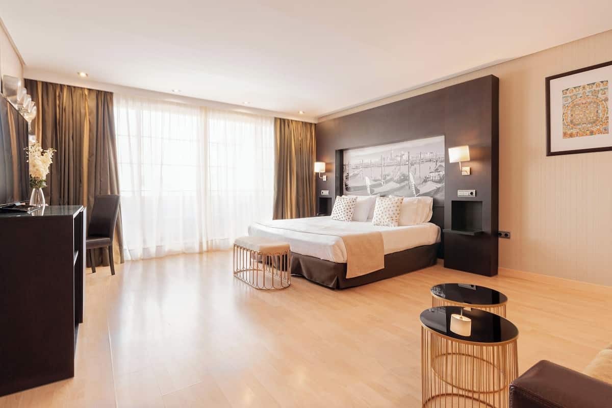 Une chambre d’hôtel moderne, dotée d’un grand lit, d’un bureau et d’un coin salon.