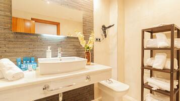 A modern bathroom with a large sink, mirror, and a towel rack.