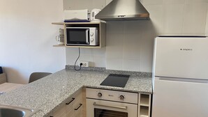 Une cuisine compacte équipée d’un four à micro-ondes, d’un grille-pain et d’un four traditionnel.