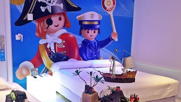 Een bed met een Playmobil-thema, met piraten- en politie-Playmobil figuurtjes, een schip en een landschapsdecor.