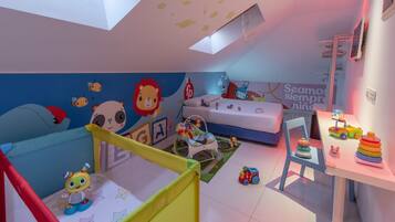 Un cuarto infantil con una cama litera, juguetes y un tragaluz en el techo.