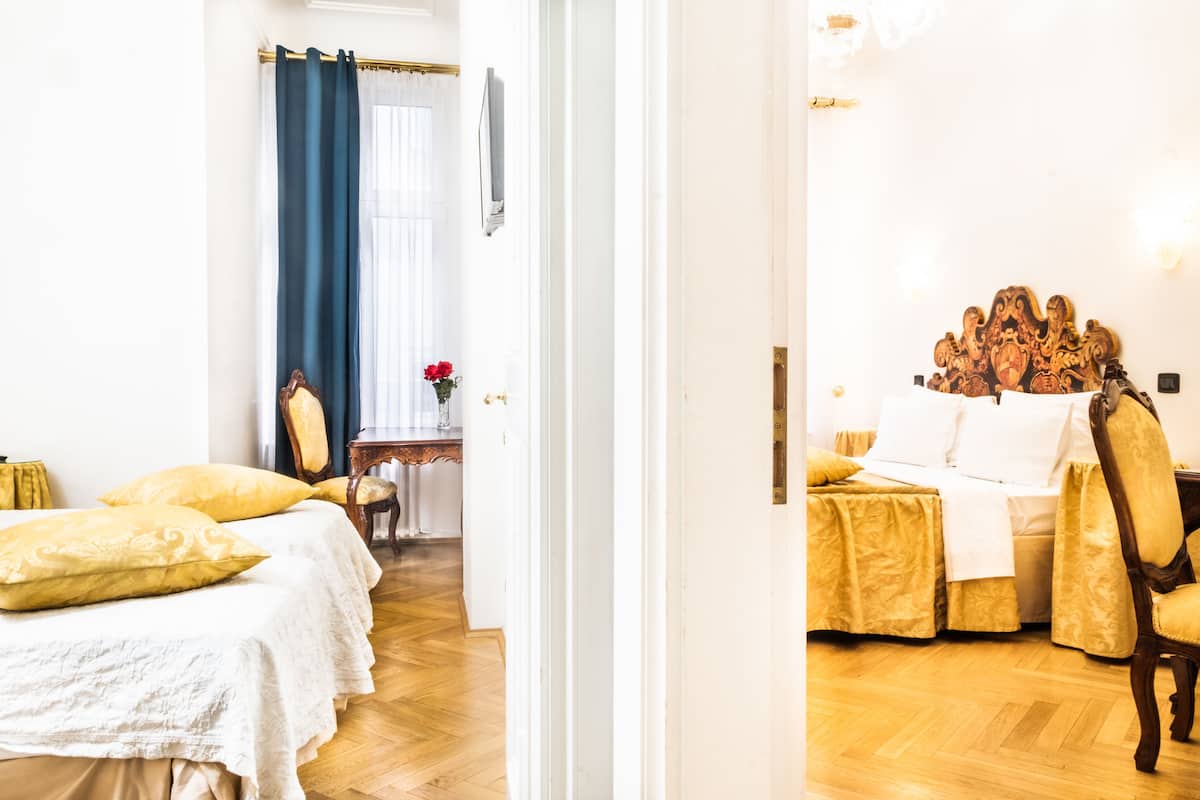 Een hotelkamer met een bed, een stoel, een tafel en een spiegel.