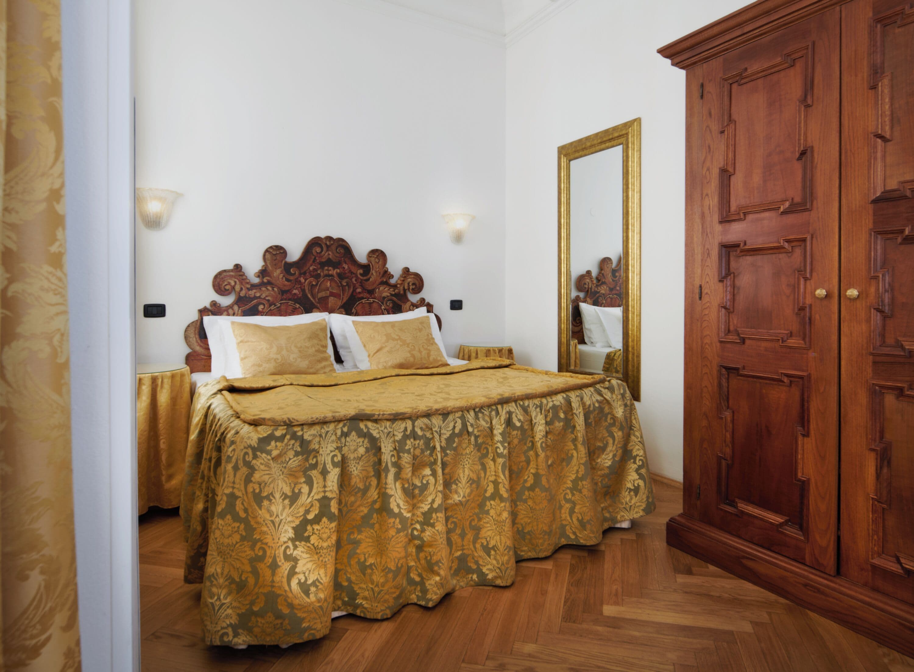 A bedroom with a wooden bed, a large mirror, and a wardrobe.