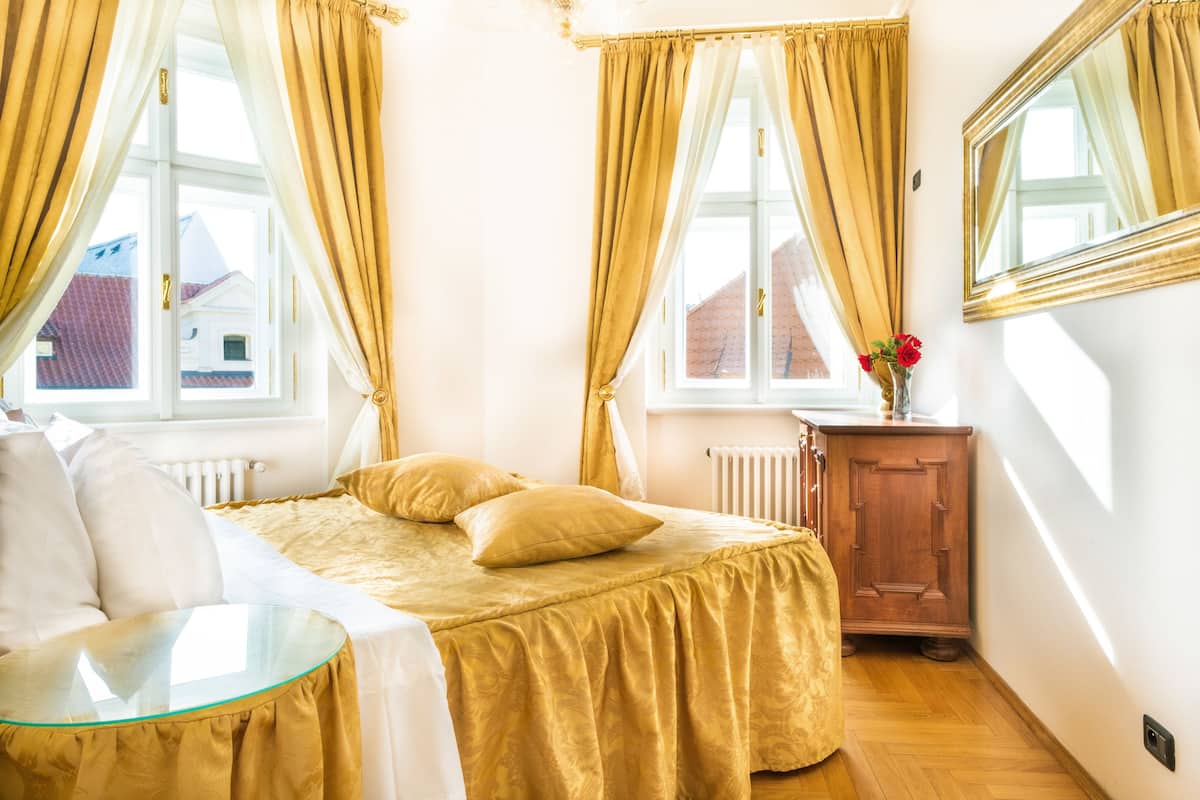 Een slaapkamer met een bed, een glazen tafel, een houten kast en een spiegel.