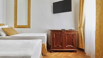 Une chambre d’hôtel avec deux lits, une armoire en bois, un téléviseur à écran plat et une fenêtre avec des rideaux.