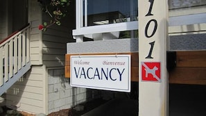 Una casa con un cartel de 'VACANCY' y el número '101' en la puerta.