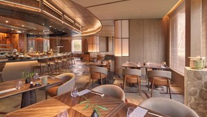 Een modern restaurant met een lange toonbank, meerdere eettafels en stoelen.