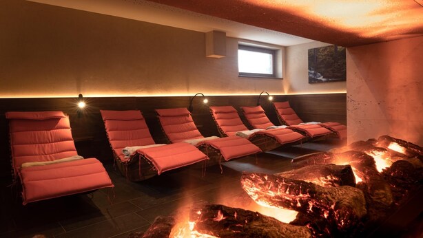 Un sauna con varias bancas y un fuego a la vista.
