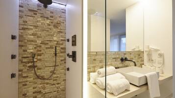 A modern bathroom with a shower, a sink, and a large mirror.