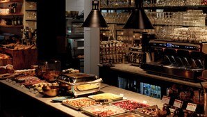 A bar area with various food items, a coffee machine, and shelves stocked with bottles. - HotelO Kathedral Antwerp (Antwerp)