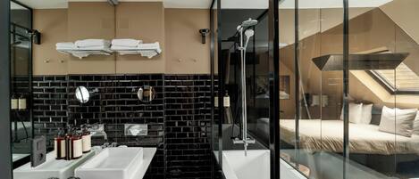 A modern bathroom with a large sink, mirror, and a glass-enclosed shower area.