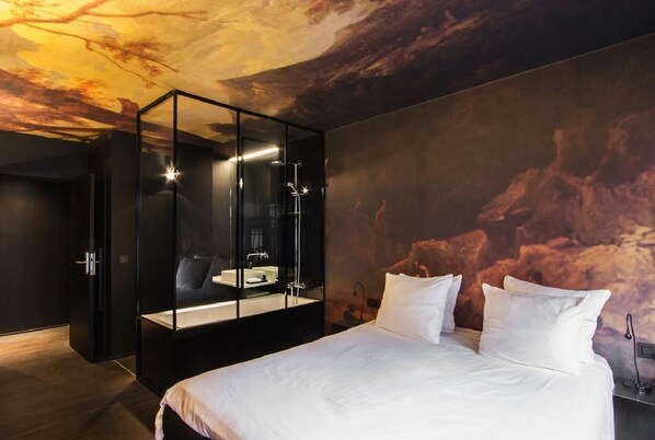 A modern bedroom with a large bed, a glass-enclosed walk-in shower, and a mural on the ceiling. - HotelO Kathedral Antwerp (Antwerp)