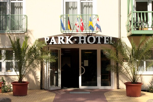 Ein Hotel Eingang mit einem Schild, auf dem "PARK HOTEL" steht.