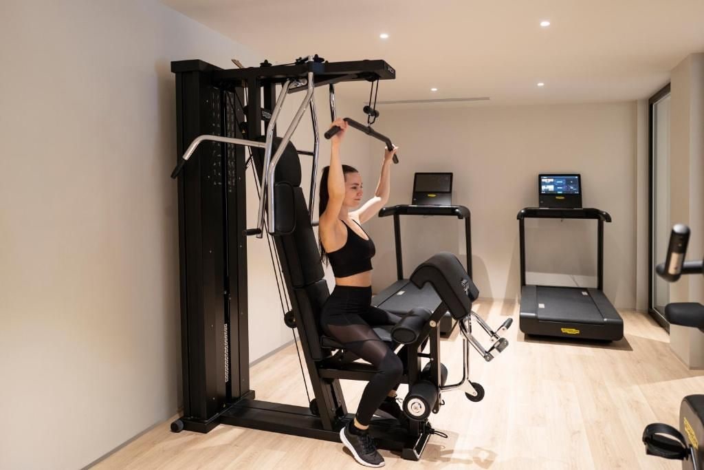 Une salle de sport équipée d’une barre de traction, d’un tapis de course et d’un vélo d’appartement.