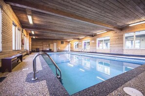 Una piscina techada, sillones reclinables de piscina