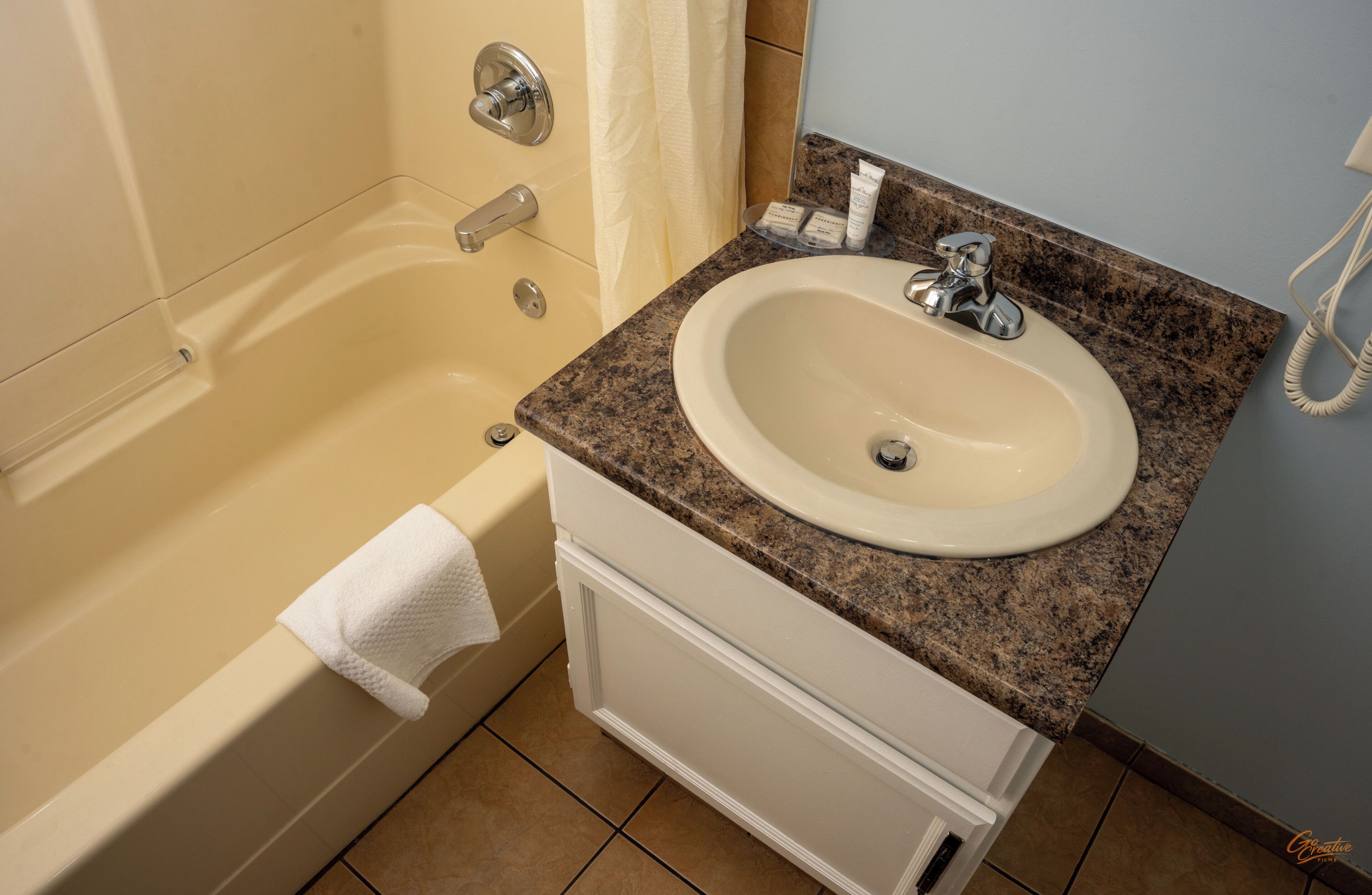 Un baño con bañera, lavabo y espejo.
