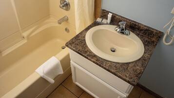 Un baño con bañera, lavabo y espejo.