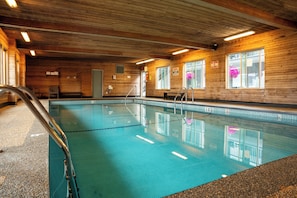 Una piscina techada, sillones reclinables de piscina