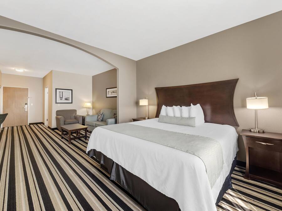 Ein Hotelzimmer mit einem großen Bett, einem Schreibtisch, einem Sessel und einer Couch.