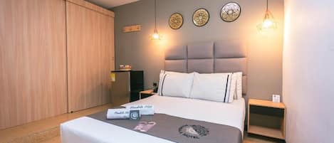 A hotel room with a bed, a bedside table, a wardrobe, and decorative wall plates.
