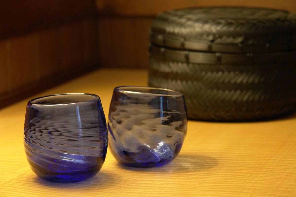 Two glass containers on a wooden surface with a tire in the background.