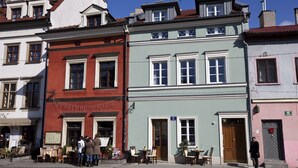 A row of colorful buildings with a café on the ground floor. - Crystal Suites Chez Helena (Kraków)