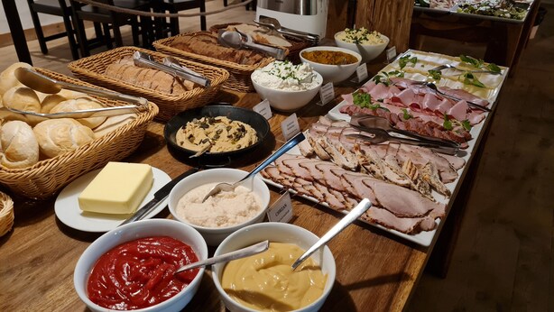 A buffet table with various food items including bread, dips, and meats. - Crystal Suites Chez Helena (Kraków)
