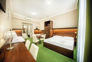 Une chambre d’hôtel avec un lit, un bureau, une chaise et une petite table.