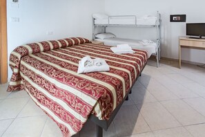 A hotel room with a single bed, a bunk bed, a desk with a computer, and a television. - Residence Siesta (Rimini)