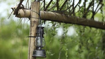 A lantern hanging from a bamboo structure in a natural setting.