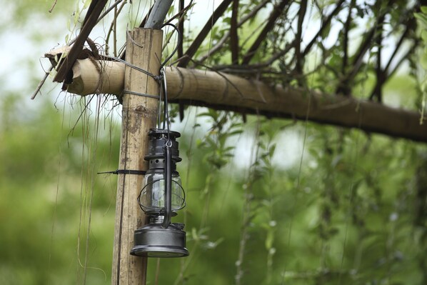 Un farol colgando de una estructura de bambú en un entorno natural.