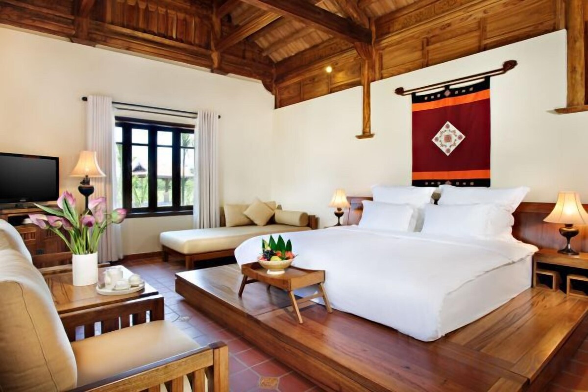 Une chambre d’hôtel avec un lit, un canapé, une petite table et un téléviseur.