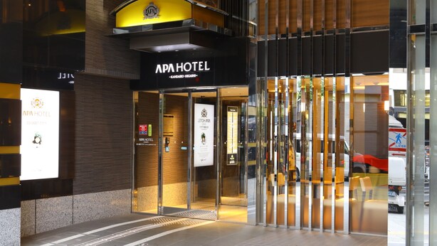 The exterior of APA HOTEL with a modern design, featuring a prominent entrance with glass doors and a yellow awning. - APA Hotel Kanda Ekihigashi (Tokyo)