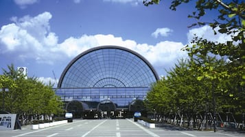 A large, modern building with a curved glass facade and a dome-like structure.