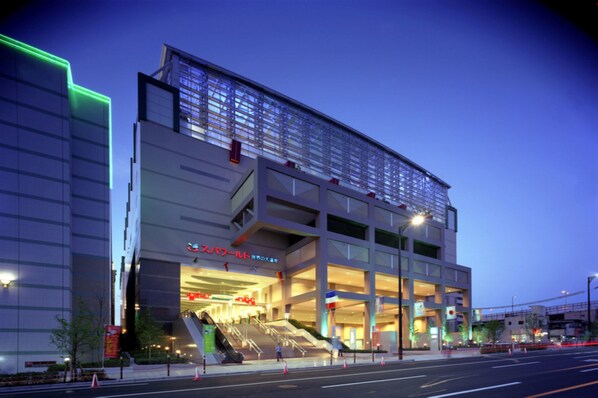 A modern building with multiple floors, large windows, and a prominent entrance with steps. - APA Hotel Namba Shinsaibashi (Osaka)