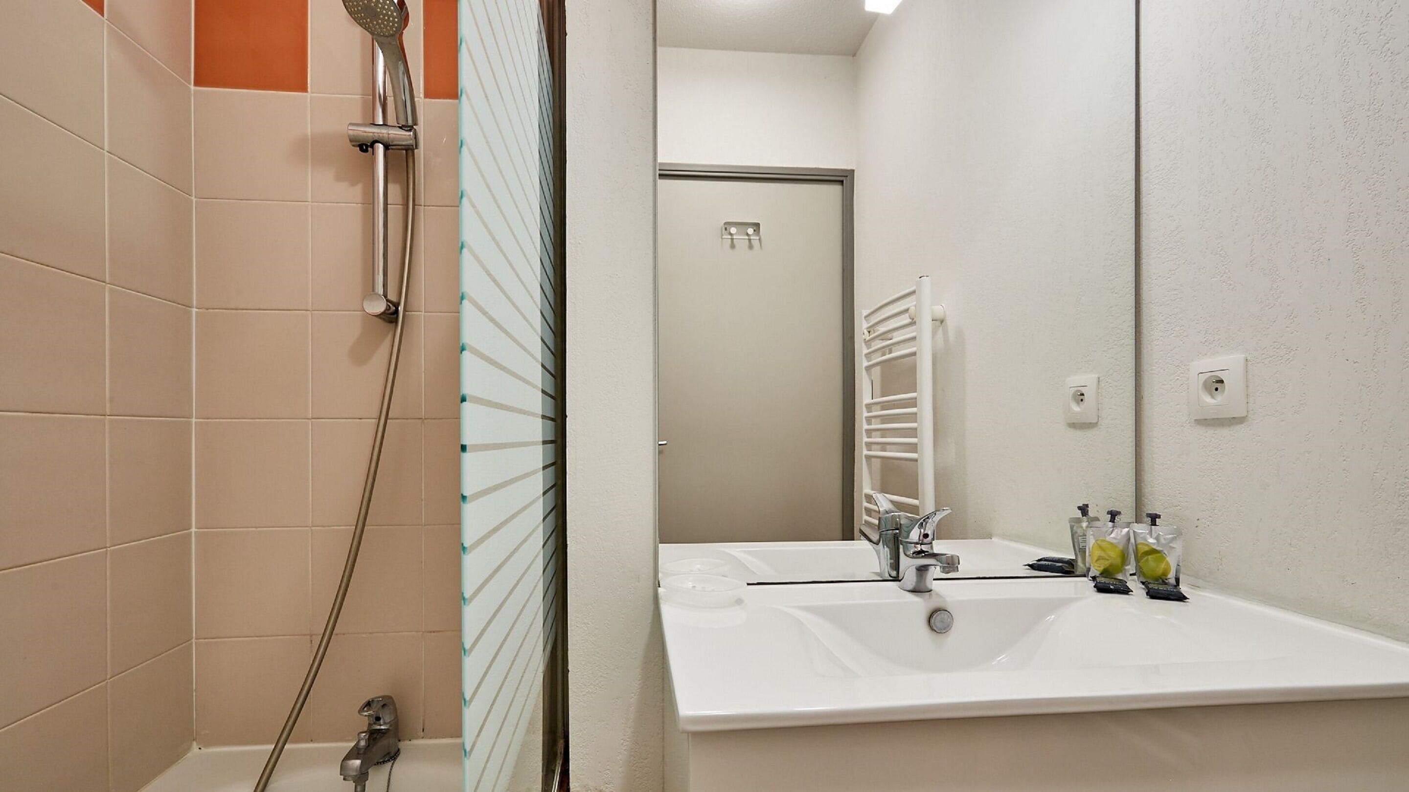 A bathroom with a shower, a sink, and a mirror.