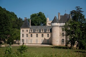 A large, historic stone castle with multiple towers and a central courtyard. - Résidence Le Clos du Rocher - Vacancéole (Les Eyzies)