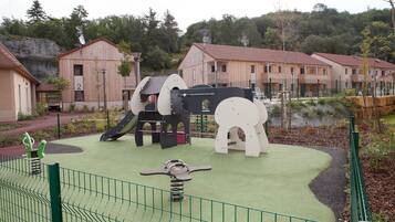 Children can play on the slide, swings, and climbing structure in this playground area.